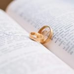 two gold colored wedding bands on book page